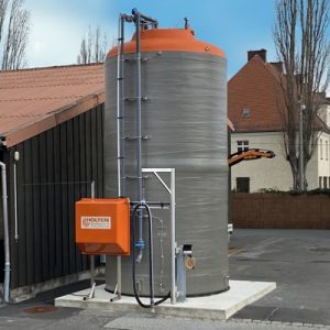 Vollständig aufgebauter Solelagertank aus GFK neben einem Firmengebäude